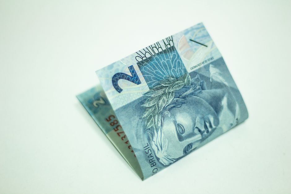 Nota de 2 reais, moeda brasileira, representando benefícios sociais e renda.